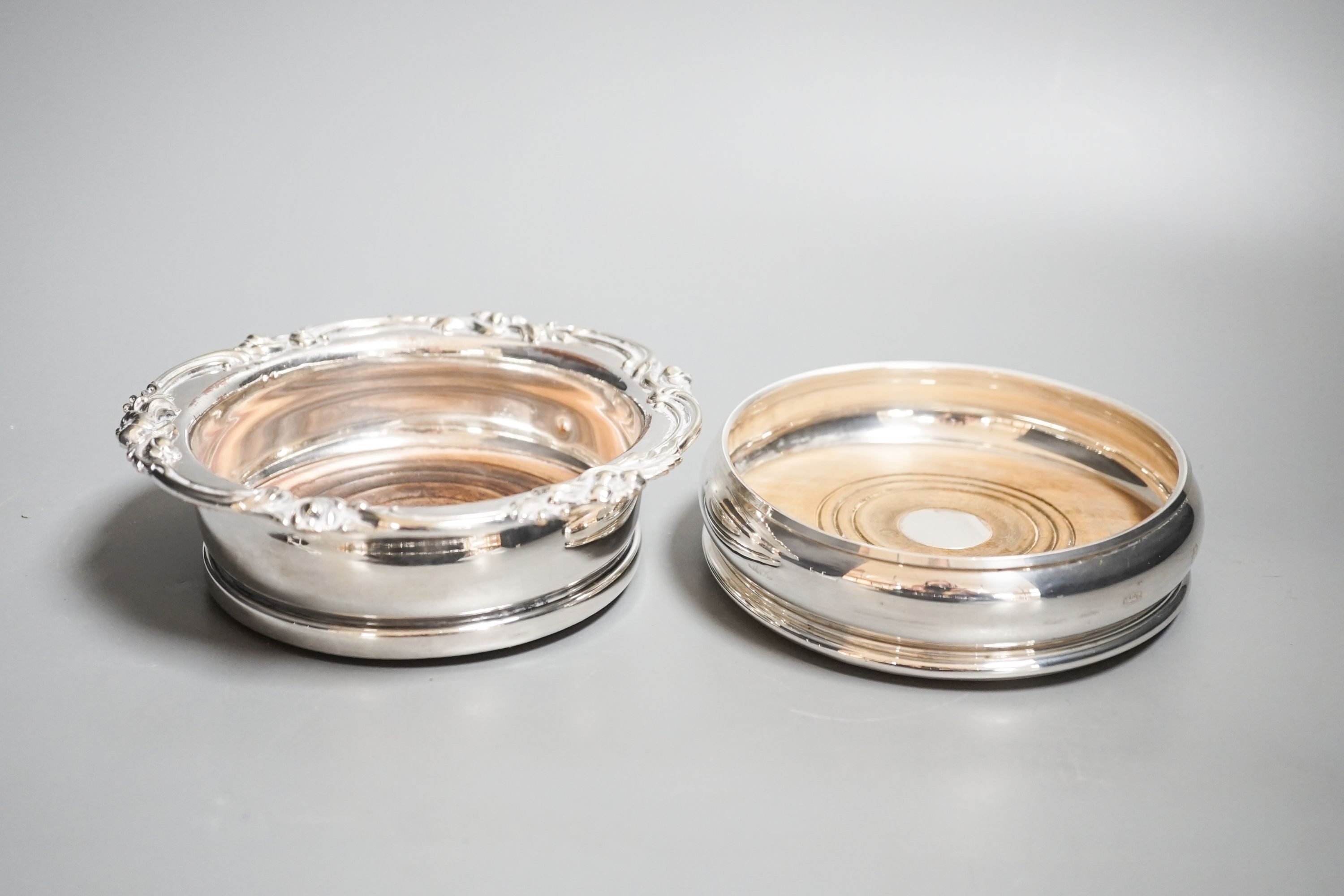 A modern silver mounted wine coaster, 12.2cm and a silver plated wine coaster.